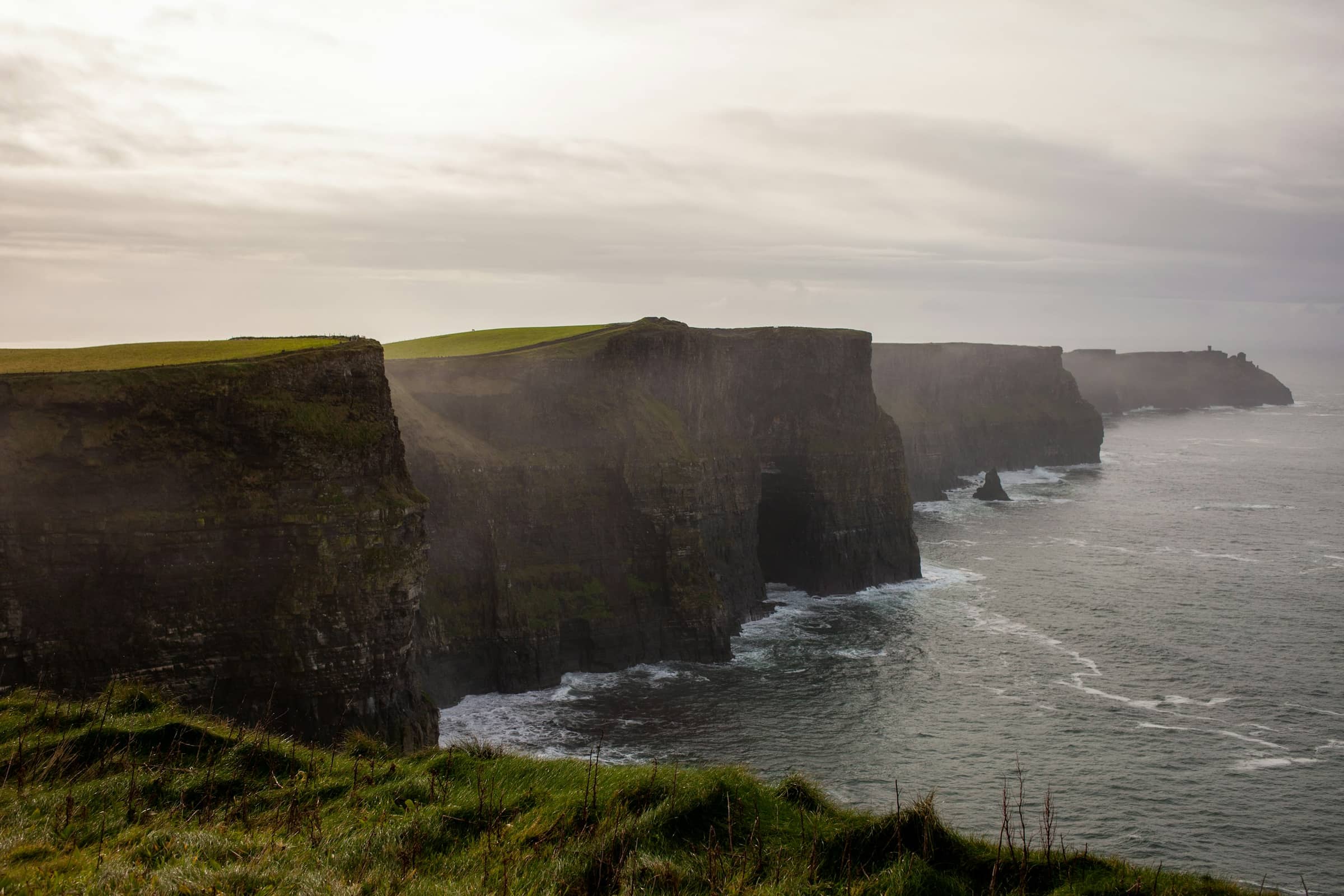 The cliffs in low mist, the sea grey and working below the headland.