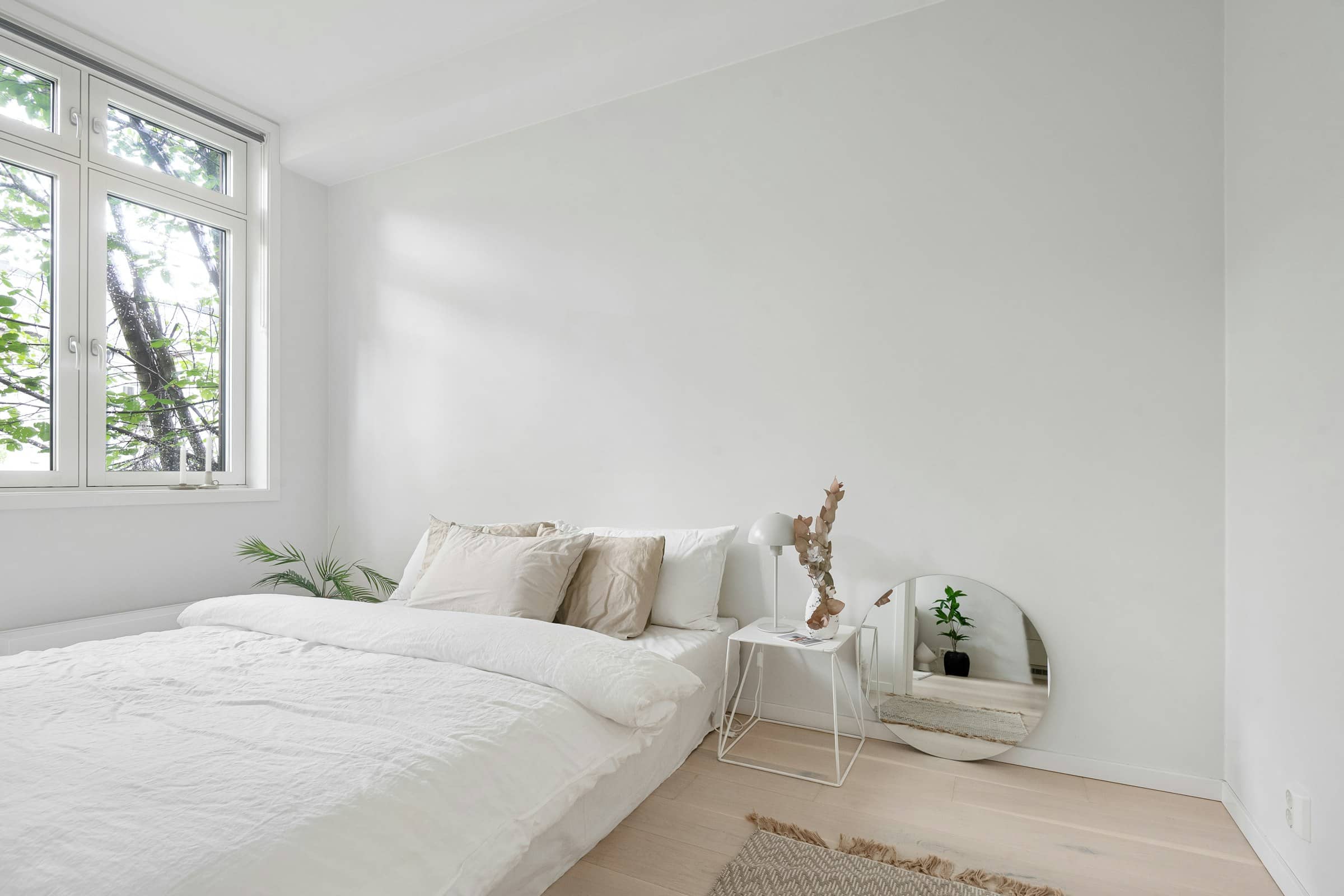 A plain room with heavy linen and a wide window full of grey sea light.